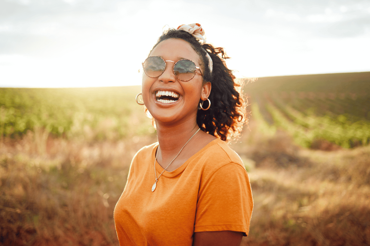 woman smiling and wearing sunglasses outside