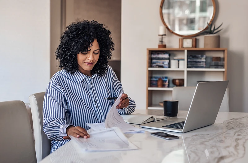 a woman working at her dining room table